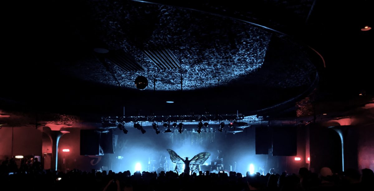 Zoe Jakes with butterfly wings on stage.